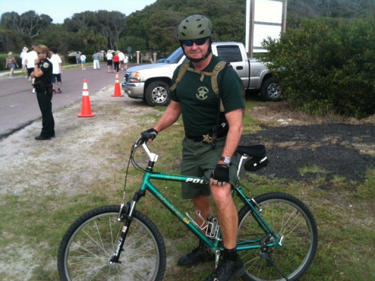 A police officer posing with his bicycle