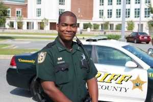 Male officer in front of car