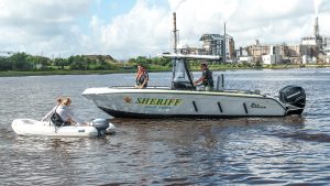 A police boat floats near a dinghy