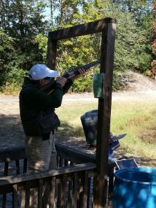 A man aiming and shooting a shotgun