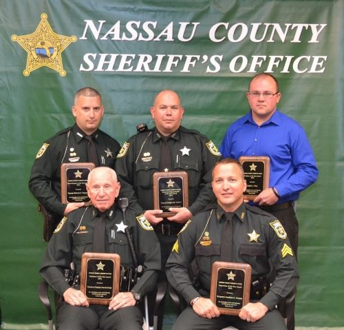 Five officers posing with plaques they were presented