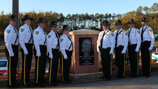 Nine officers pose with Eric James Oliver memorial