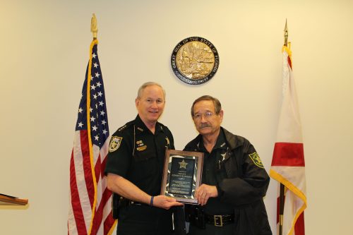 Deputy Kenneth Homan being presented a plaque by an officer
